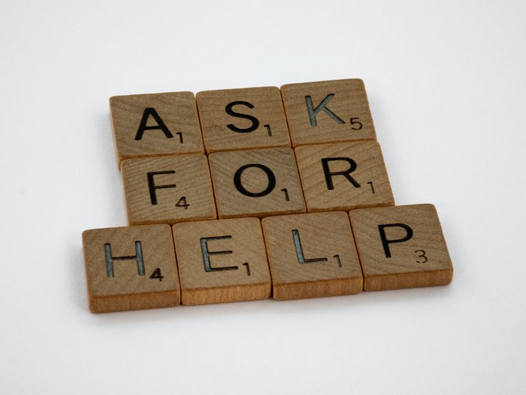 Wooden scramble tiles spell the words 'Ask for help'