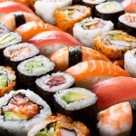 A selection of sushi: Nigiri, maki rolls with tuna, salmon, shrimp, crab and avocado.
